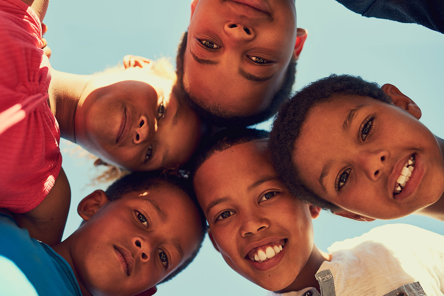 group of 5 African American children looking down at camera