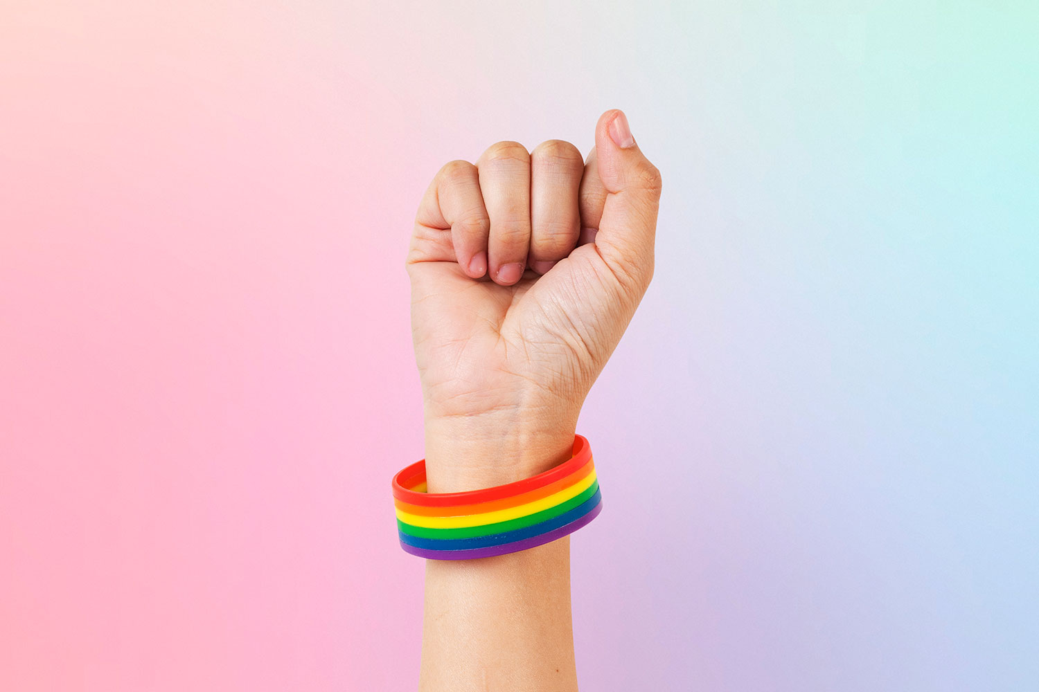 fist raised in air with rainbow bracelet
