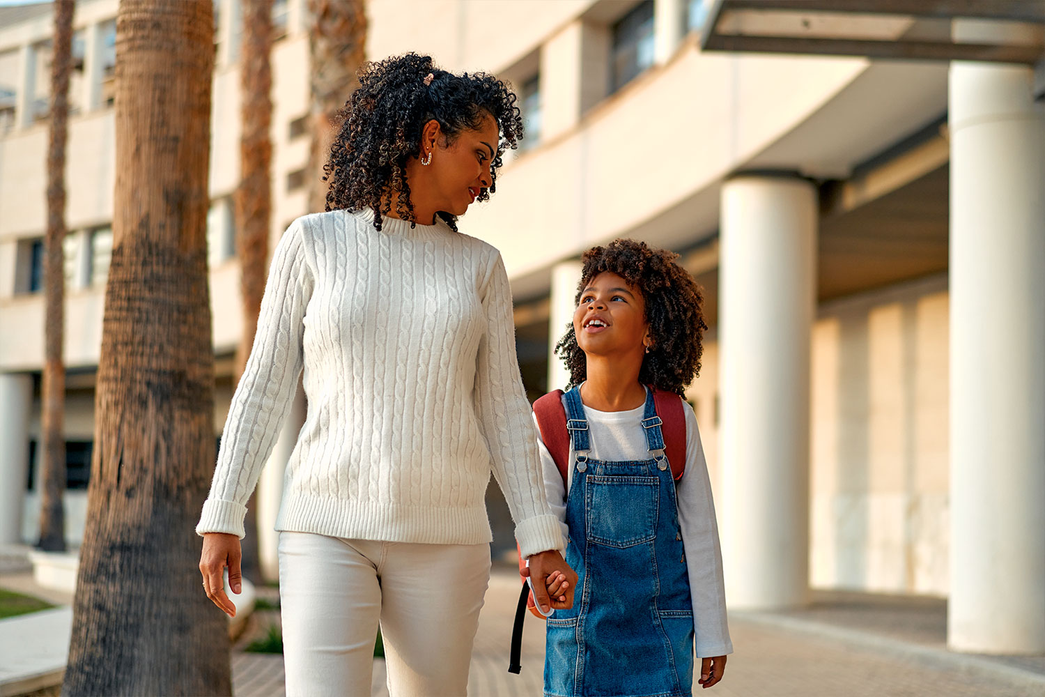African American mother and daughter walking outside