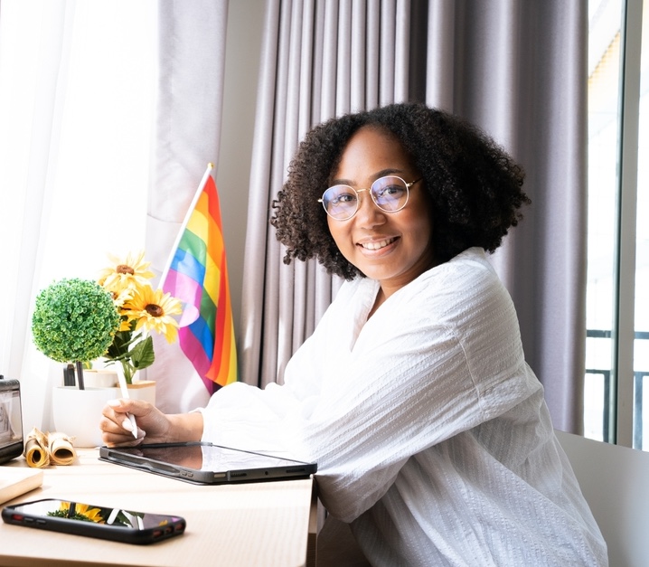 African American woman working with LGBTQ+ flag on her desk
