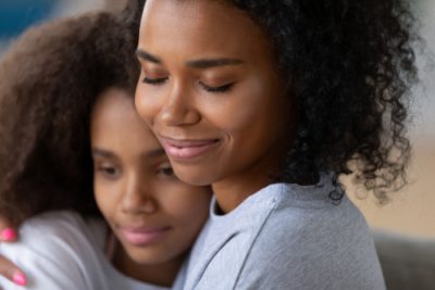 close up of mother and daughter embracing