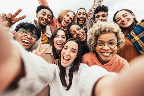 A large group of young people smiling at the camera for a selfie. 