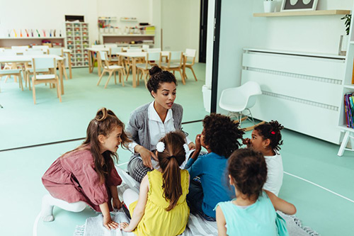 children sitting around a teacher in a school setting